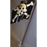 A painted plywood theatre prop flag, decorated with skull and crossbones, with mounting plate. H.