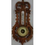 An early 20th Century German barometer, within a foliate carved wood surround. H.