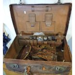 An early 20th Century tan leather gentleman's travelling toilet case, fitted five silver top jars,