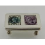 A novelty silver stamp box, the hinged lid set with two enamel plaques designed with stamps,