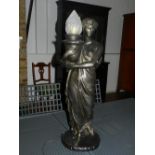 A cast plaster table lamp in the form of a classical figure holding a burning cauldron, H. 76cm.