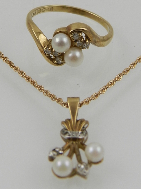 A 9 carat yellow gold, diamond, and pearl set pendant on a 9 carat yellow gold chain,