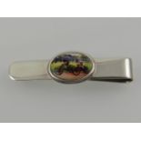 A sterling silver and enamel tie clip, set enamel plaque depicting two cyclists.