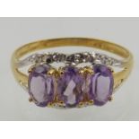 A 9 carat yellow gold and amethyst ring, set three oval cut amethysts,