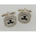 A pair of silver and enamel cuff links.