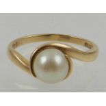 A 9 carat yellow gold and pearl crossover style ring.