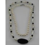A string of 9mm white pearls, fastened with a white metal clasp, together with a black onyx and
