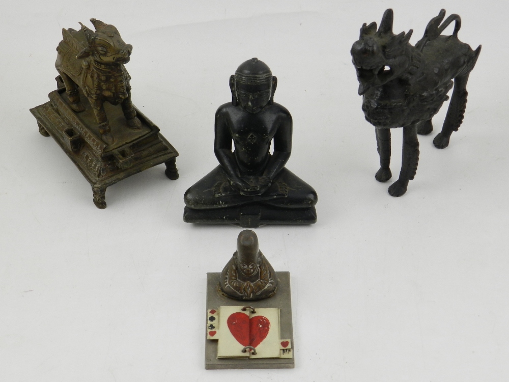 A carved soapstone Buddhist figure together with two other cast bronze pieces and a wist marker