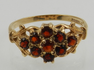 A 9 carat yellow gold and garnet set floral cluster ring.