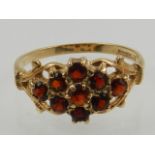 A 9 carat yellow gold and garnet set floral cluster ring.