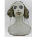 A late 20th century pottery doll's head bust with a partial horse-hair wig, the reverse bearing