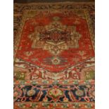 A red ground Heriz carpet, of Serapi design, within stylised floral borders. L.275cm W.184cm