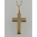 A 14 carat yellow gold cross pendant, suspended on a 9 carat yellow gold chain.