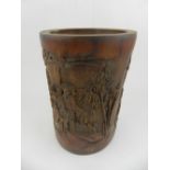 A Chinese bamboo brush pot, carved with figures and a pagoda in landscape.