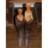 A pair of brown leather gentleman's riding boots, together with boot stretchers.