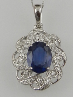 An 18 carat white gold, diamond, and sapphire pendant, in an openwork cluster mount.