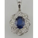 An 18 carat white gold, diamond, and sapphire pendant, in an openwork cluster mount.