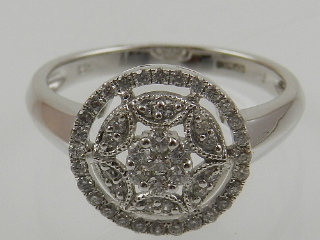 An 18 carat white gold and diamond cluster ring, in an open work mount.