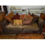 A Contemporary two seater leather sofa, having upholstered seats and various scatter cushions,