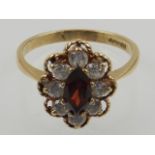 A 9 carat yellow gold, garnet, and diamond oval cluster ring.