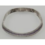 A silver, cubic zirconia and amethyst line bracelet.