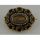 A Victorian Momento Mori yellow metal, enamel, and seed pearl brooch, with central glass aperture