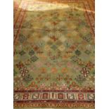 An olive ground Khorason carpet, decorated with stylised flowers to centre, within many borders. L.