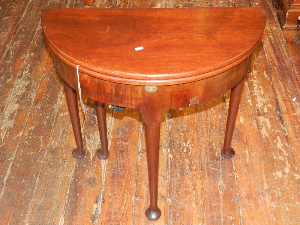 A George III mahogany demi-lune gate-leg tea table, having hinged lid enclosing a compartment,