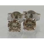 A pair of champagne diamond ear studs, of approx. 0.74 carats combined.