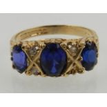 A 9 carat yellow gold, diamond, and blue stone (possibly sapphire) ring.