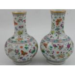 A near pair of Chinese famille rose squat baluster porcelain vases, decorated with butterflies