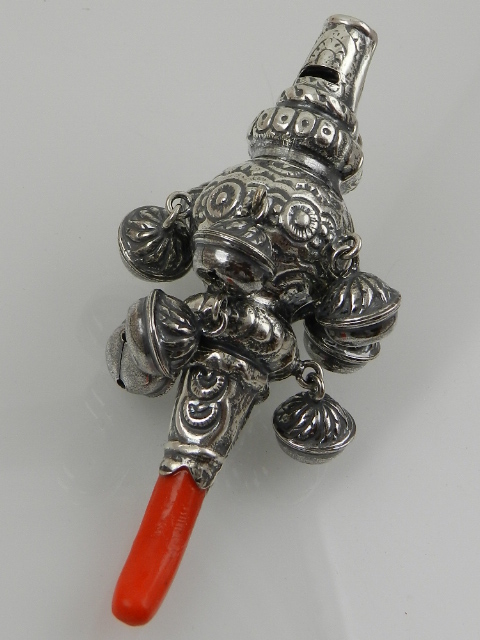 A white metal babies rattle, in the 19th century taste.