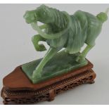 A carved jade figure of a horse in animated pose, on carved and pierced wood base H.