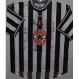 A framed Newcastle United football shirt circa 1998, signed by the squad including Shearer,