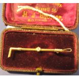 A cased late Victorian yellow gold riding crop bar brooch with diamond set shaft.