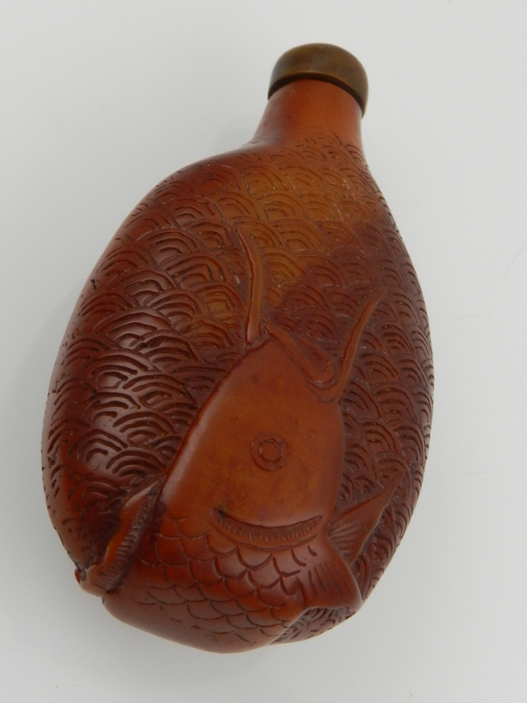 A Chinese resin snuff bottle, decorated with a fish swimming amongst waves. H.10cm