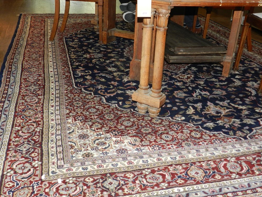 An red ground Tabriz carpet, having quatrefoil medallion to centre on a scrolling foliate ground,