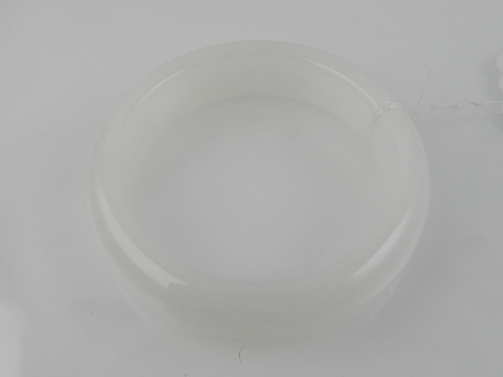 A Chinese white hard stone bangle. Internal diameter approximately 6cm.