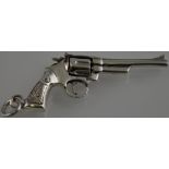 A silver miniature pistol with revolving chamber