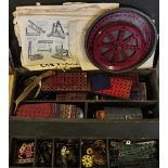 A quantity of early Meccano  contained in a black tin covered trunk with instruction booklet and