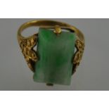 A jade dress ring the rectangular stone claw set in a yellow stone band
