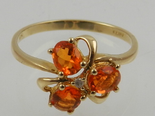 A 10 carat yellow gold and tangerine citrine three stone floral cluster ring.