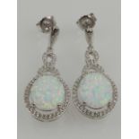 A pair of silver, opalite, and cubic zirconia set cluster drop earrings.