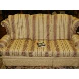 A Contemporary three-seater sofa, upholstered in a striped and floral fabric on a cream ground.