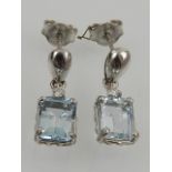 A pair of 18 carat white gold, diamond, and aquamarine drop earrings, each set an emerald cut
