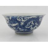 A Chinese blue and white bowl, decorated with dragons chasing pearls amongst stylised clouds and