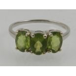 A 9 carat white gold and peridot three stone ring.