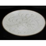 A Chinese Ding style dish, having low relief decoration of stylised flowers. D.20cm