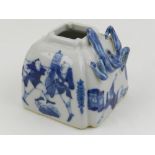 A Chinese blue and white brush pot, moulded with dragons to top, decorated with warriors. H.6cm