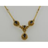 An 18 carat yellow gold and sapphire drop pendant necklace.